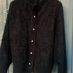 Misiu svart ”fluffig” kofta med fina knappar - Jättefin svart kofta sydd i en jätteskönt tyg, Jag säljer denna för att jag köpte i förstor storlek och kunde inte byta, den är oanvänd! Jag är storlek S men denna kofta skulle sitta perfekt för storlek L!🥰 Pris kan diskuteras. 