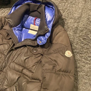 Moncler jacka SÄLJER BILLIGT - Köptes på kaspersheat.com. Authentication på monclers hemsida samt digitalt kvitto. En unik moncler jacka i brunaktig färg och blå innanpå som ej finns kvar i butik. Passar ca 170-185cm. Sälje för att jag köpt ny jacka. Hör gärna av dig för mer info.
