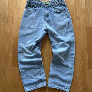 Ljusblåa baggy jeans med fet brodyr på fickorna!! Bra skick men med små, mycket lättfixade defekter (se sista bilden). 🫶🏻 Pris kan diskuteras.   Nypris: 1300 kr Mått 📏 Midja: 43 cm Ytterben: 103 cm Innerben: 76 cm Benöppning: 22,5 cm