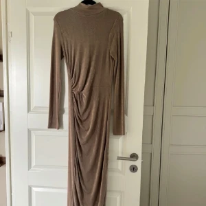 Långklänning - oanvänd - Oanvänd klänning köpt från fashionnova för 499kr. Oanvänd, endast testad. Passar alla mellan XS-M pga stretchig material. Färgen är lite mörk beige.  Priset kan diskuteras!