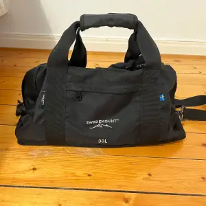 Svart gym bag/duffel bag från swedemount. Original pris 400:-. Mycket bra skick då den är endast använd ett fåtal gånger. Har bara används för resor. Svart färg, rymmer 30 L
