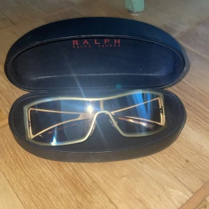 Ralph lauren glasögon - Solglasögon, har en minimal rispa på ens linsen men är knappt märkbar annars som nyskick.