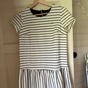Klänning Tommy Hilfiger  - Söt klänning från Tommy Hilfiger med lappen kvar. Volangen sitter lite längre ner på höften och ger en fin siluett. Strl 164  Aldrig använd bara testad. Köparen står för frakten 💕