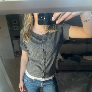 Kortärmad kofta - Grå kortärmad kofta med knappar ifrån peppercorn! I fint skick i storlek S, passar nog upp mot M då den är lite stor i storleken!