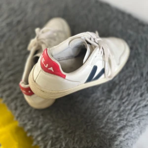Veja skor - Säljer mina vita veja skor med marinblå och röda detaljer. Använt få gånger. Säljer för att de ej kommer till användning. Är storlek 37 men passar mig så vanligtvis använder 38.  Skriv för fler bilder. Pris går att diskutera. KÖP DIREKT FÖR 450kr!!