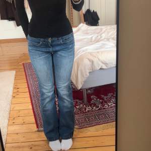 Midrise/Lowrise blåa bootcut jeans med mönster på bakfickorna 🩵 Midja: ~38cm, Ytterbensmått: ~103cm, Innerbensmått: ~80cm