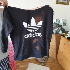 Adidas hoodie - En svart adidas hoodie som har blivit tvättad med Vanish därav dom orangea fläckarna. Annars i fint skick och sparsamt använd. Hämtas i Malmö. 