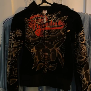 Ed Hardy Track Suit  - Ed Hardy tracksuit / dress för kvinnor!! Sjukt fin i sammet / velour, med mycket detaljer. Överdelen: Medium, sitter som en small, rhinestones på ryggen & specialgjord dragkejda.  Underdelen: Åtdragbara snören för midjan, med flared längst ner. Sthlm