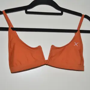 Orange bikiniöverdel med en V-ringning detalj från Boutine LA. Justerbara band, utan vaddering. Använt 2ggr. 