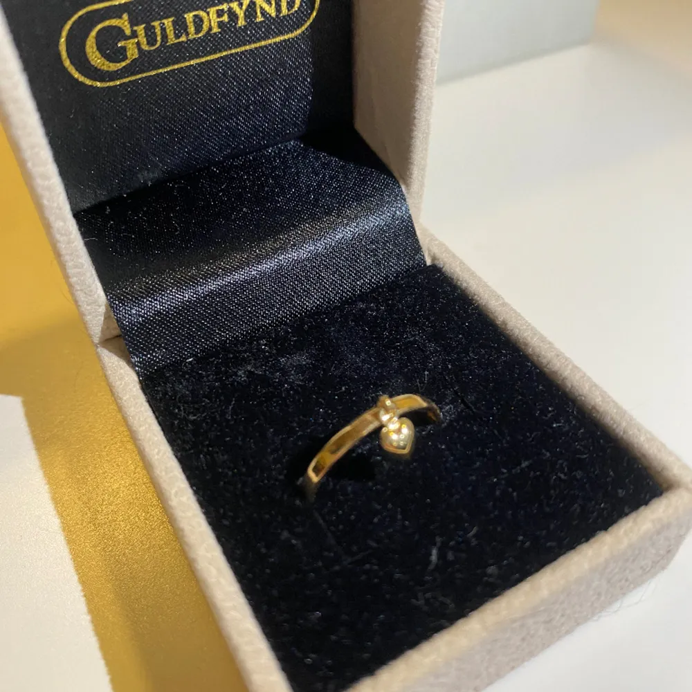 En guldplaterad ring i 18k och väger 0.5g, köptes för 1498kr. Ringen är i storlek 16,5. Heter ”Tunn ring med liten hjärtberlock i 18K guld” på Guldfynd. Aldrig använd pågrund av fel storlek. Säljer för 1000kr men priset kan diskuteras. . Accessoarer.