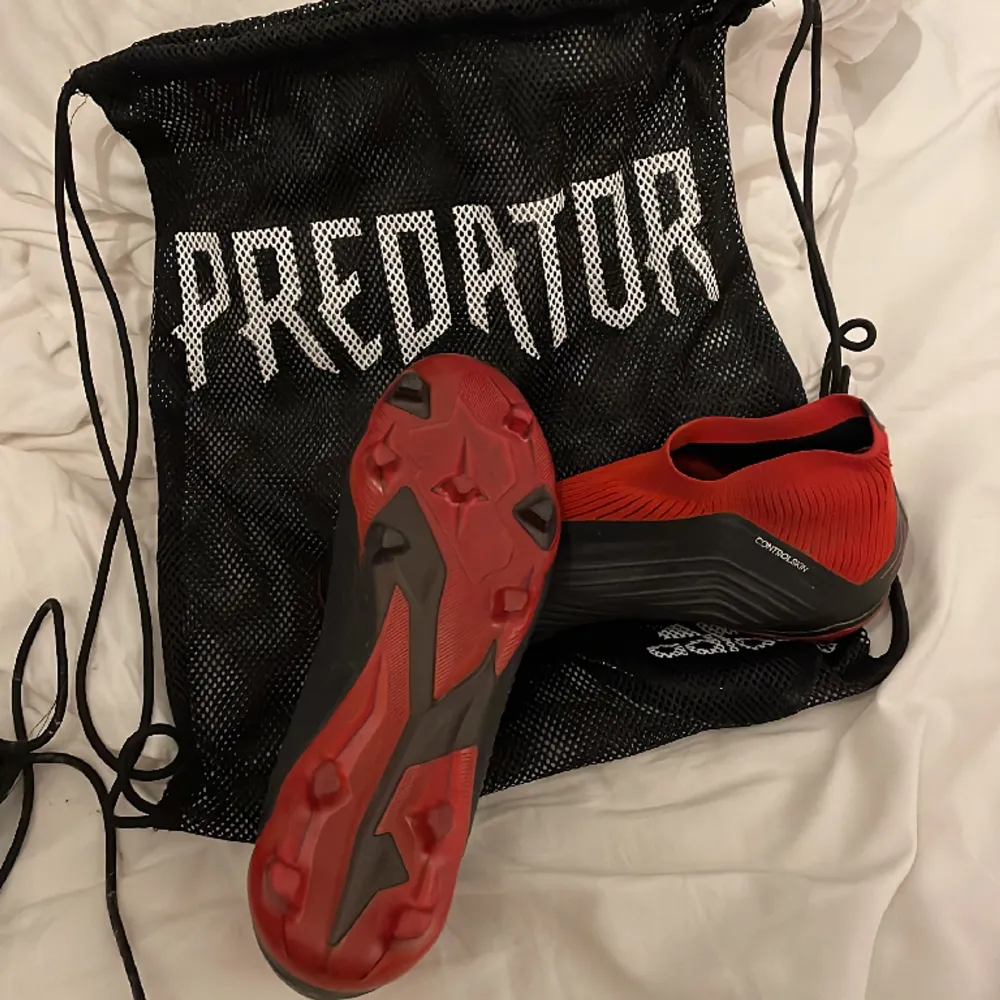 Adidas predator 18+ i färgen svart/röd. Sparsamt använda, lite smutsiga men annars felfria, storlek 38 2/3.. Skor.