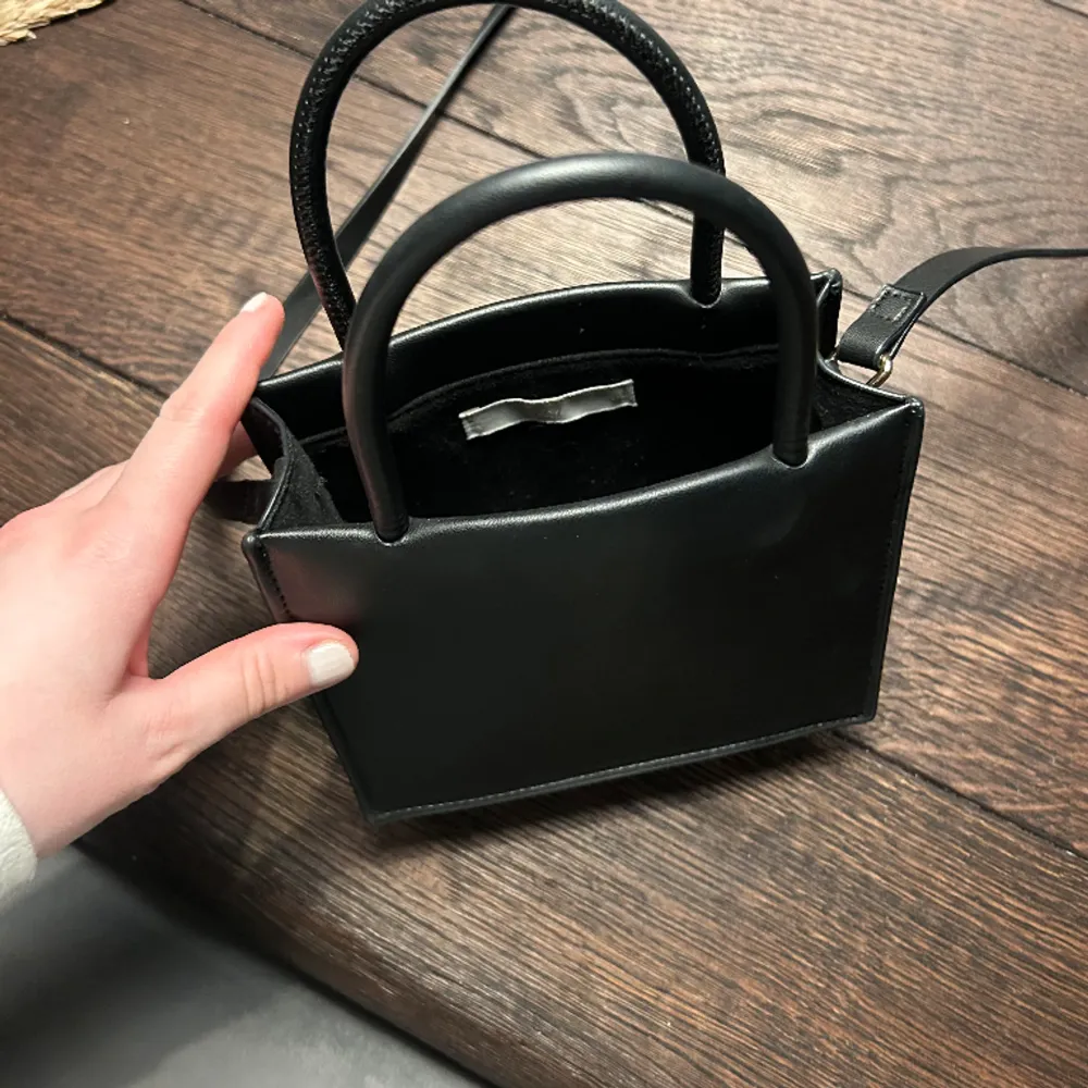 En svart väska från H&M.. Väskor.