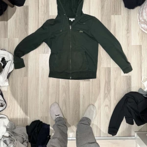 Lacoste zip up hoodie - Tjena säljer denna riktigt snygga Lacoste zip up hoodien, skick 10/10. Ny pris 1700, Tveka inte på att höra av dig om du är intresserad!