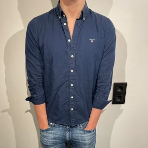 Mörkblå gant skjorta - Tja, säljer denna stilrena mörkblå gant skjorta i storlek 170cm, men sitter som en vanlig S! Hör av dig om du har minsta fundering🤝 Modell: 183cm, 72kg