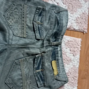 Jeans  - Ett par grå blå byxor som är lite sirvliga / har blivit för små 