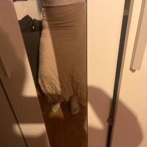 Beige midikjol - Beige midikjol, i siden material med scrunch på sidan