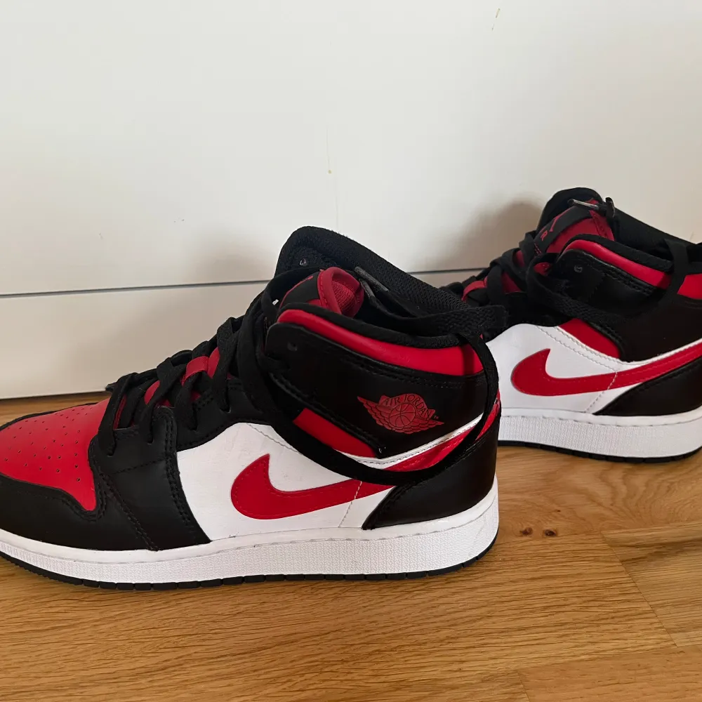 Ett par AIR JORDAN 1 MID(GS) i färgen Black/Fire red-White. Andvända ett fåtal gånger och upplevs som nyskick. Låda medföljer. Storlek 37.5, skriv för intresse av fler bilder!. Skor.