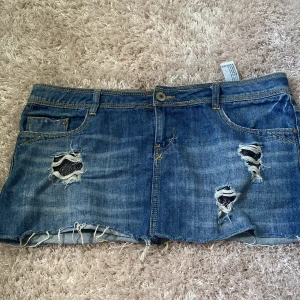 Lågmidjad jeanskjol - Jeanskjol i bra skick, glittriga fickor som syns i hålen på kjolen.  Mått- 42 rakt över midjan och 29 i längd💗💗