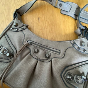 Handväska - En helt ny handväska i färgen brun/grå i skinn material🤎Köpt på en marknad i Spanien, säljs pga inte kommer till någon användning. + Man får även med en plånbok som tillhör väskan på köpet))