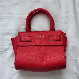 20cm x 15cm, gullig liten handväska i märket Guess, ganska dåligt skick då stor del av färgen gått av.