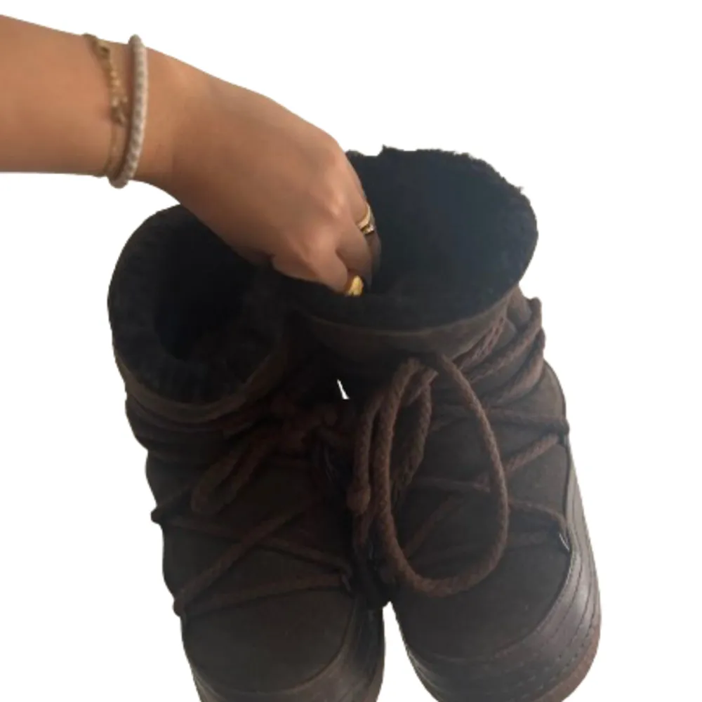 Bruna, vinter boots från INUIKKI!    varmt sherling material inne i skon.   Ena skons snöre har lösts upp nån millimeter.    . Skor.