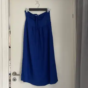 Blå klänning med snörning fram till. Jag är 165cm och klänningen går till mitten på smalbenet. Jag har använt den ett fåtal gånger så den är i mycket bra skick. 