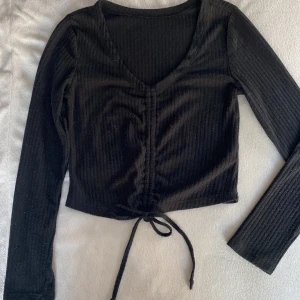 Svart topp  - Svart topp med dragsko så den går att ha både som magtröja och ”vanlig” den är ribbad och jätte fin💞 perfekt både till vardags eller kanske konserter i sommar🙌🏻🙌🏻 den är nopprig därav priset men har använt noppermaskin och försöker ta bort innan frakt💞