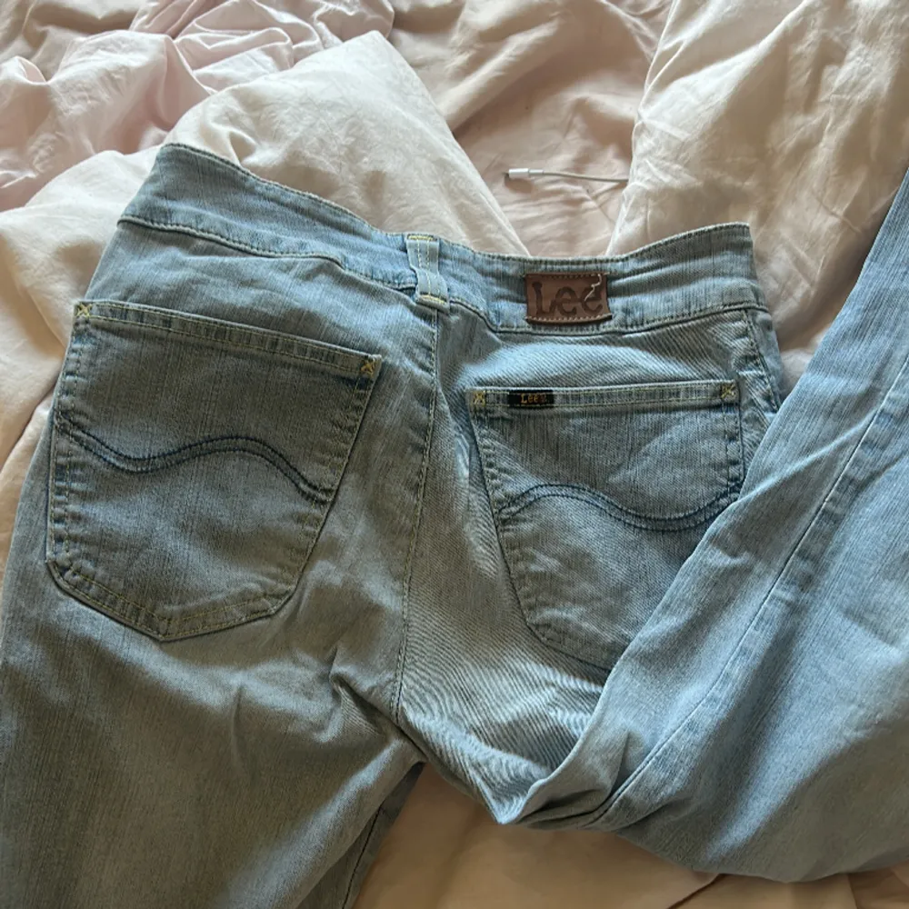 Säljer dessa jätte fina ljusblåa lågmidjade bootcut Lee jeansen i storlek S! De har ett hål vid knät och är nyanvända 💕. Jeans & Byxor.