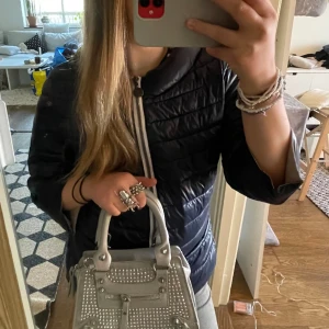 Grå handväska 💘💘 -  Säljer denna as snygga och trendiga handväskan! Den är aldrig använd och kommer inte till användning💘  Den har inga defekter och är aldrig använd! Lägg bud om du är intresserad eller kontakta mig om frågor💘💘 finns axelband till