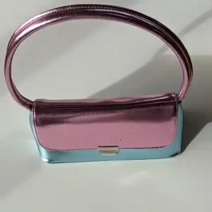 Jätte fint väska med rosa och blå färg, Glamours märke, köpte från Asos websida  I fint använt skick lite brister syns på bilder men de syns knappt när man har väskan på sig. Behöver du flera bilder? Hör av dig 