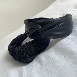 Två hårdiadem - Två svarta hårdiadem, ett i läder imiterat, och ett vanligt svart. Ny skick. 