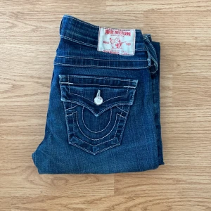 True Religion Jeans - !skicka bud för snabb affär! Fina true religion lågmidjade jeans, storlek 26 i midjan. Är kille så har ingen bild me på. Modellen är bootcut. Skriv om ni undrar någonting eller vill om ni vill ha fler bilder.