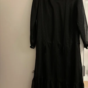 Svart prickig klänning - En snygg klänningen till sommaren, den är svart med skimrande prickar, helt ny aldrig använt prislappen sitter kvar! I storlek 34. Priset kan diskuteras vid snabb affär 