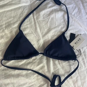Marinblå bikini överdel🤍 - Säljer denna mörkblå bikiniöverdel från na-kd.🤍 Helt oanvänd prislapparna sitter kvar. Bikinin är slutsåld på hemsidan. 