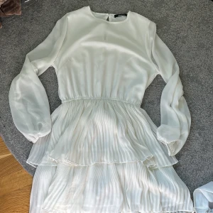 Vit klänning - Vit puffig klänning, perfekt till sommaren. Långärmad och nästan aldrig använd.