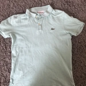 Lacoste piké  - Nästan helt oanvänd Lacoste piké i bra skick och skön färg. Storlek ses på fjärde bild. Pris kan diskuteras. 