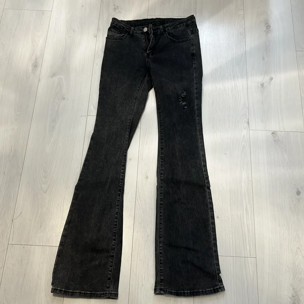 Stretchiga grå Utsvängda byxor med en detalj på låret. Använda 1 gång💕. Jeans & Byxor.