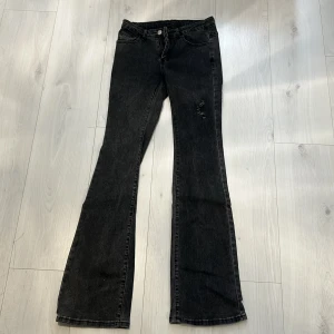 Utsvängda Jeans - Stretchiga grå Utsvängda byxor med en detalj på låret. Använda 1 gång💕
