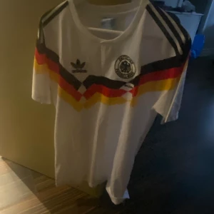 Fotbollströja - Säljer en retro tröja från 1988-1990 (Tyskland) Materialet är väldigt lent och tunnt så det blir perfekt nu när solen börjar komma fram men även om man ska träna eller bara latcha.