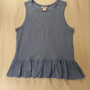 Monki ljusblå volang topp - Säljer denna volangtopp då den aldrig kommit till användning. Nyskick och helt oanvänd, endast testad. Inga fläckar eller defekter. Stor i storleken, skulle själv säga strl XS. Har utgått ur sortimentet. 