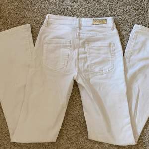 Vita, denim jeans från ONLY - low waist och bootcut. Inga defekter. 30 cm över midjan och 75 cm i innerbenslängd. Nypris 500 kr