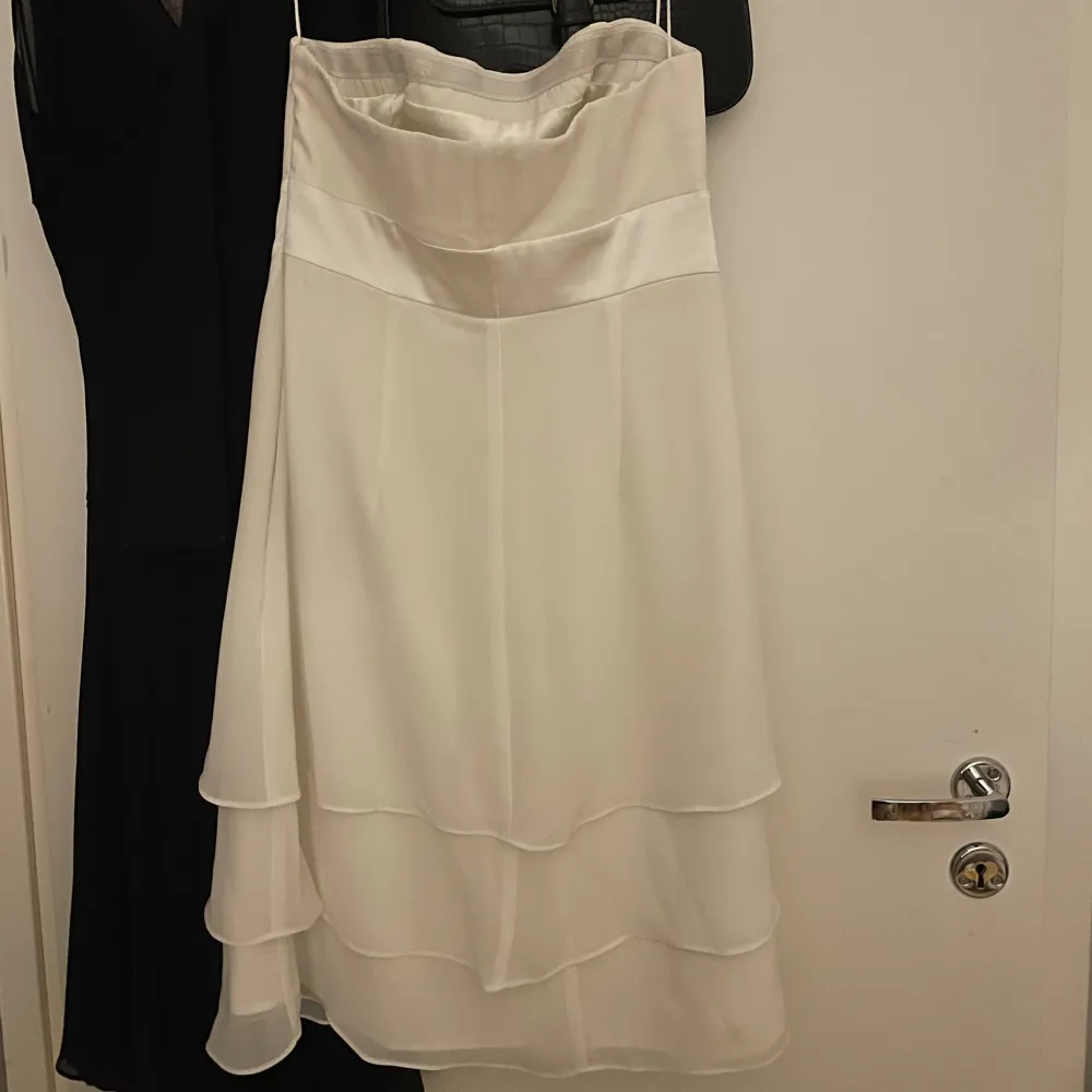 Jättefin vit klänning perfekt till studenten! Axelbandslös men den glider inte ner💕 band på framsidan som går att knyta till en fin rosett🎀. Klänningar.