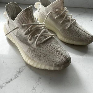 Yeezy 350 V2 ”Bone” - Fick skorna i present men jag använder de inte. Använda max totalt 10 gånger, låda finns. 45 1/3 passar 28-29 cm långa fötter. 1699kr  1699 kr