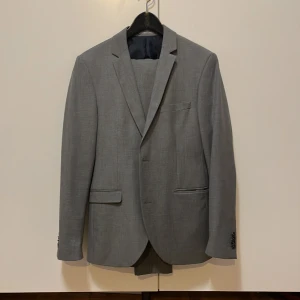 Knappt använd kostym - Bra skick, knappt använd. Skulle säga att den passar någon runt 175 med smal kroppsform. Ganska slim fit.