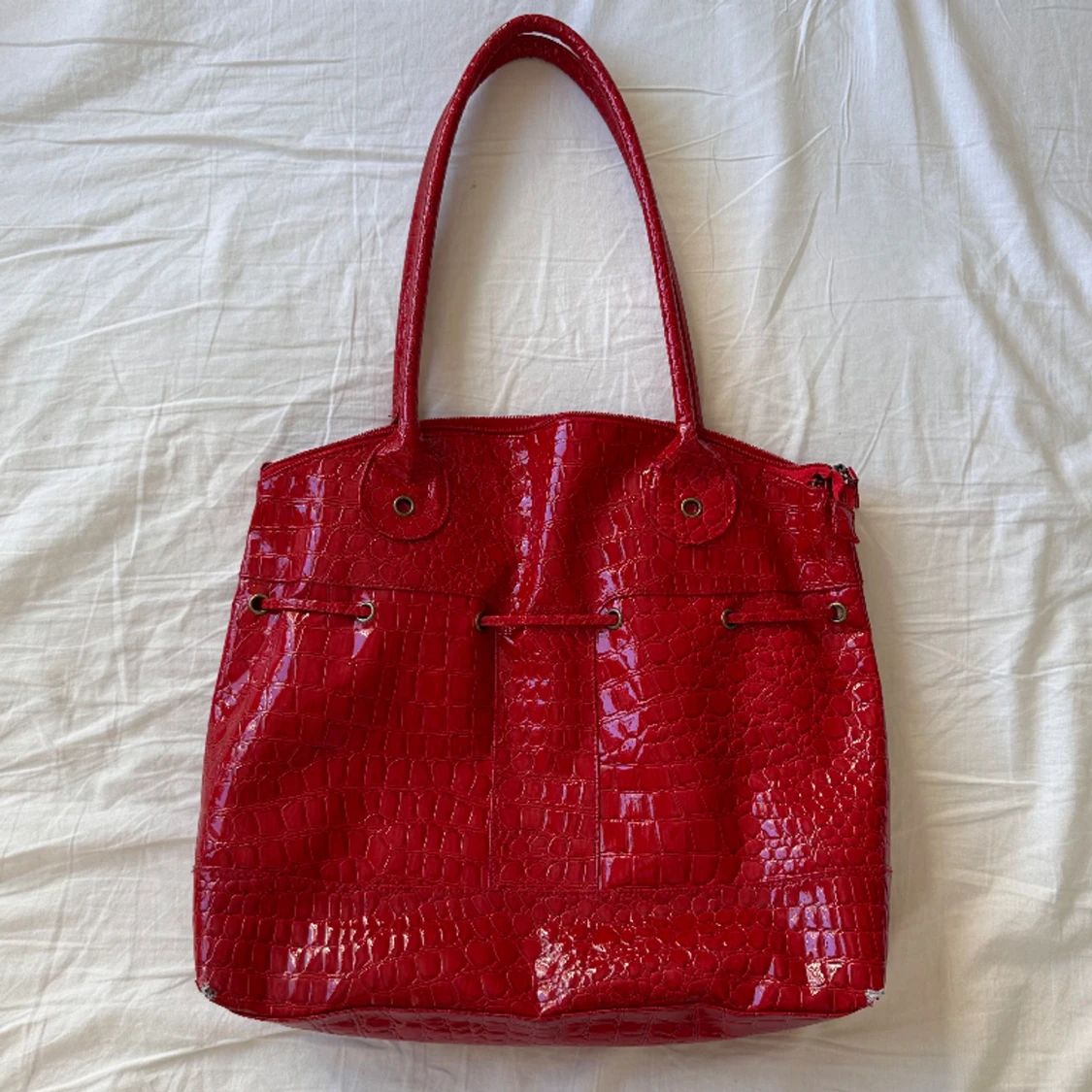 Röd väska i lackskinn liknande material