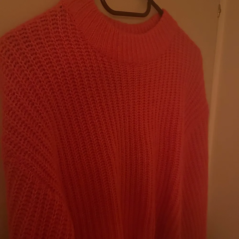 En rosa stickad tröja som är rätt liten i storleken. I mjukt material och i mycket bra skick.. Stickat.