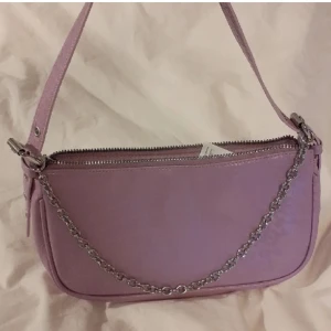 Väska - Säljer denna ljus lila väska från H&M i nyskick för att den tyvärr inte kommer till användning. Hör av dig om du har några frågor eller funderingar.💜