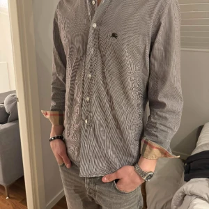 Burberry Skjorta - Säljer nu min fina burberry skjorta! Den är storlek L men kan även passa M. Den är i fint väldigt fint skick! Nypris ligger på 5000kr men jag säljer för endast 1250kr! Skicka bud! (Pris inte hugget i sten)