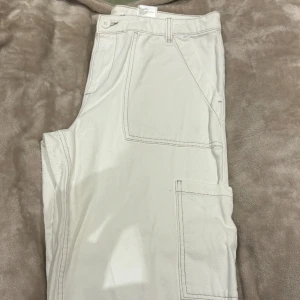 Vita jeans  - Vita jeans med beigea sömmar. Storlek 42! Medföljer en extraknappar som bilden visar! Bara använda ca 2 gånger!  Vid övriga funderingar eller behov av fler bilder så skriv! 