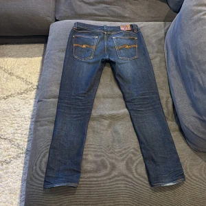 Nudie jeans - Detta är ett par feta nudie jeans. Dem är sparsamt använda och har därför nästintill inga defekter, inte urtvättade eller hål osv. Säljs pga de är för stora för mig och vill hitta några andra. Priset är inte i sten. Hör av för minsta fråga!